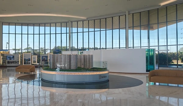 Interior view of Nambiar District 25 sales gallery featuring a detailed architectural scale model of residential towers on a circular display stand