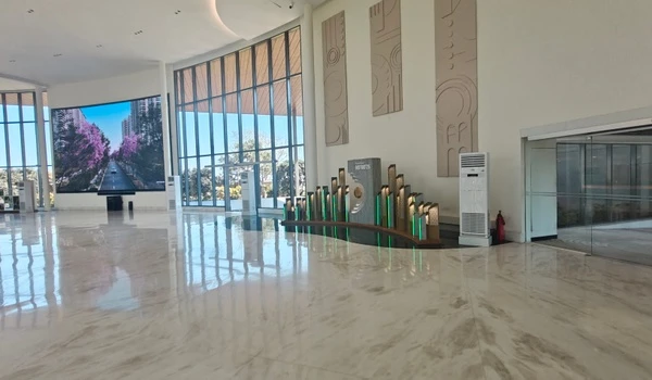 Interior view of Nambiar District 25 marketing office featuring a creative stylized skyline display with green lighting and the project logo