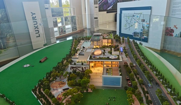 Full wide-angle view of the Nambiar District 25 clubhouse architectural model showcasing the exterior design, landscaping, and luxury amenities