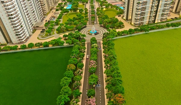 Aerial view of Nambiar District 25 showing the tree-lined entrance boulevard, central roundabout with fountain, and surrounding high-rise towers