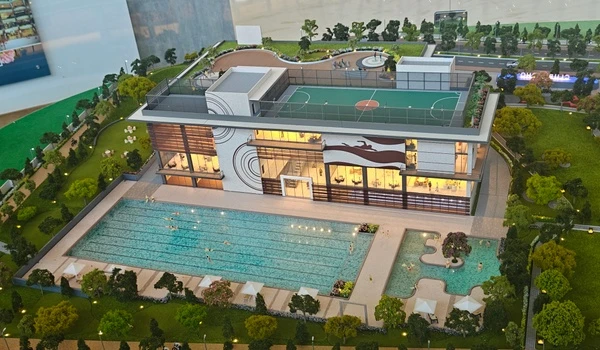 Architectural model of Nambiar District 25 clubhouse featuring a large lap pool, kids pool, and poolside leisure deck